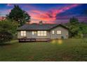 Home's serene backyard with a wooden deck, lush green lawn and mature trees for privacy at 3035 Landington Way, Duluth, GA 30096
