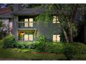 Two-story condo with brick accents and a covered balcony surrounded by lush landscaping at dusk at 1205 Mcclelen Way, Decatur, GA 30033