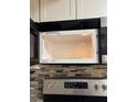 Stainless steel microwave with tiled backsplash and modern appliances at 2565 Terrace Trl, Decatur, GA 30035