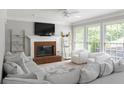 Bright living room with fireplace, large windows, and comfortable seating area with plush sofa and chairs at 3075 Milford Sw, Marietta, GA 30008