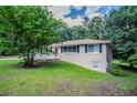 View of home showing beautiful lawn, large tree and side entrance at 3920 Stonewall Tell Rd, Atlanta, GA 30349