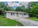View of home with red door, driveway and professional landscaping at 3920 Stonewall Tell Rd, Atlanta, GA 30349