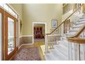 Grand foyer featuring hardwood floors, high ceilings, and a staircase with carpeted steps and white railings at 935 Brookline Way, Alpharetta, GA 30022
