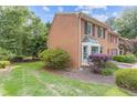 Charming brick townhome with black shutters and a well-manicured lawn at 1995 Raleigh Tavern Dr, Roswell, GA 30076