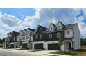 New townhome exteriors showcase a modern design with dark trim, white accents, and individual garages at 210 Sharon Ln, Loganville, GA 30052