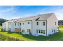 A view of the back of new townhomes, featuring a grassy backyard and modern white siding at 210 Sharon Ln, Loganville, GA 30052