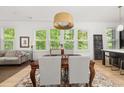 Elegant dining area with large windows, a modern pendant light fixture, and an open layout to the living spaces at 262 Southerland Ne Ter, Atlanta, GA 30307