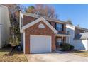 Red brick two-story home showcasing the attached one-car garage and neatly landscaped front yard at 538 Shadowmoore Dr, Riverdale, GA 30274