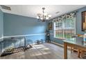 Bright dining room featuring a modern chandelier and a large window bringing in natural light at 575 Chapel Walk Ln, Lawrenceville, GA 30045