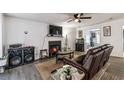 Comfortable living room features a fireplace, TV, ceiling fan, and leather reclining sofa at 575 Chapel Walk Ln, Lawrenceville, GA 30045