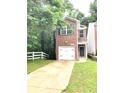 Brick facade home featuring an attached garage, contrasted with lush greenery at 2849 Windsor Forrest Ct, Atlanta, GA 30349