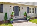 Inviting front door entrance with brick steps, potted plants, and stylish outdoor lanterns at 4493 Orleans Dr, Dunwoody, GA 30338