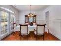 Elegant dining room with wainscoting, chandelier, and natural light from the door at 4619 Sweetwater Ave, Powder Springs, GA 30127