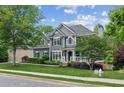 Two-story home with gray siding, a lush front yard, and a side-entry garage at 2572 Hillgrove Dr, Dacula, GA 30019