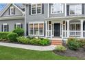 Close up of the home's front entrance with attractive landscaping and a covered porch at 2572 Hillgrove Dr, Dacula, GA 30019