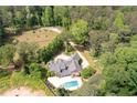 Stone home with pool, wooded lot, and long driveway showcasing privacy and seclusion at 355 Clark Creek Pass, Acworth, GA 30102