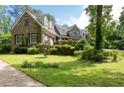 Stately stone house with lush front yard featuring a two-car garage and mature trees at 355 Clark Creek Pass, Acworth, GA 30102