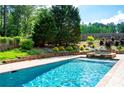 Sparkling pool features a tanning ledge and attached spa surrounded by lush landscaping and a private backyard at 355 Clark Creek Pass, Acworth, GA 30102