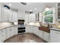 Bright kitchen with white cabinets, granite countertops, stainless steel appliances, and a farmhouse sink at 4390 Wicklow Ct, Suwanee, GA 30024