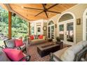 Inviting covered porch with a swing, fan, and comfortable seating area with a fire pit at 4390 Wicklow Ct, Suwanee, GA 30024