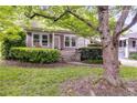 Home exterior featuring a well-maintained yard with mature tree and manicured bushes at 959 Hall Nw Pl, Atlanta, GA 30318