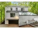 Unique home exterior with a flat roof section and large glass greenhouse feature at 165 River North Walk, Atlanta, GA 30328