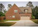 Rear exterior view showcasing a brick facade and a spacious two-car garage at 237 Arborview Dr, Mcdonough, GA 30252