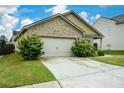 Home with an attached two-car garage, spacious driveway, and nicely landscaped front yard at 2671 Calvary Dr, Hampton, GA 30228