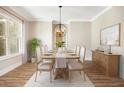 Elegant dining room featuring hardwood floors, modern lighting, and neutral décor at 1150 Sweet Mia Ln, Powder Springs, GA 30127
