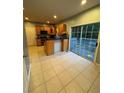 Cozy kitchen featuring tile flooring, wood cabinets, and a sliding glass door to the outdoor patio at 1951 Bergerac Sw Ct, Marietta, GA 30008