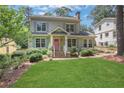 Inviting two-story home with a manicured front yard, trimmed shrubbery, and a pink front door at 47 Roseclair Se Dr, Atlanta, GA 30317