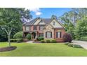 Charming two-story brick home with stone accents, well-manicured lawn, and mature trees at 5925 Water Mark Dr, Cumming, GA 30040