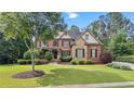 Charming two-story brick home with stone accents, well-manicured lawn, and mature trees at 5925 Water Mark Dr, Cumming, GA 30040