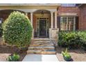 Elegant stone steps leading to a covered front porch and stylish front door at 5925 Water Mark Dr, Cumming, GA 30040