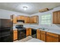 Functional kitchen with wooden cabinets and black appliances offering practical cooking space at 6185 Marbut Farms, Lithonia, GA 30058