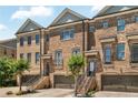Brick townhome featuring a two-car garage and manicured landscaping at 1547 Cambridge Pl, Marietta, GA 30062