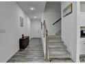 Bright hallway with wooden floors, stairs, and a decorative cabinet at 6125 Langdon Way, Cumming, GA 30028