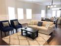Bright living room featuring a comfortable beige sofa, stylish blue armchairs, and hardwood floors at 2132 Memorial Se Dr, Atlanta, GA 30317