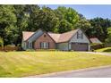Attractive single-Gathering home featuring a well-manicured lawn, brick accents, and a spacious two-car garage at 3335 Ivy Lake Dr, Buford, GA 30519