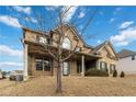 Charming two-story brick home with a covered front porch and mature tree at 3823 Dragon Fly Ln, Loganville, GA 30052