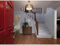 Bright foyer featuring hardwood floors, a staircase with wooden banister, and decorative lighting at 517 Sheritan Sw Way, Smyrna, GA 30082