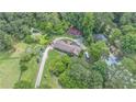 Aerial view of a tree-surrounded home featuring a circular drive, pool, outbuildings, and ample parking at 2452 Camp Mitchell Rd, Grayson, GA 30017