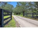Long driveway leading to a secluded property with a black fence on both sides at 2452 Camp Mitchell Rd, Grayson, GA 30017