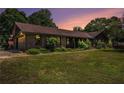 Charming brick home featuring lush green lawn and mature landscaping with a warm sunset backdrop at 2452 Camp Mitchell Rd, Grayson, GA 30017