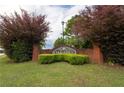 Landscaped Oak Hill community sign with brick base and lush green foliage on a cloudy day at 40 Oak Hill Dr, Covington, GA 30016