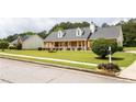 Beautifully landscaped home featuring mature trees, manicured lawn, and brick exterior with dormer windows at 40 Oak Hill Dr, Covington, GA 30016