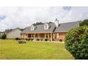 Picturesque exterior of brick house with dormer windows, covered porch, and lush green lawn at 40 Oak Hill Dr, Covington, GA 30016