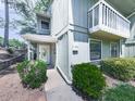 Inviting condo exterior featuring a white door, a small balcony, and lush landscaping at 708 Hanover Se Ln, Marietta, GA 30067