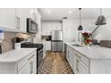 Modern kitchen featuring white cabinets, stainless steel appliances, and a functional island with pendant lighting at 2528 Shropshire Pl, Mcdonough, GA 30253
