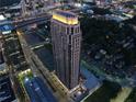 An aerial view of a modern, high-rise apartment building at dusk, showcasing the building's unique architecture at 270 17Th Nw St # 3606, Atlanta, GA 30363